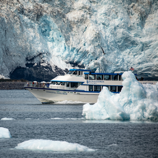 A Kenai Fjords Tour boat sailing past a glacier